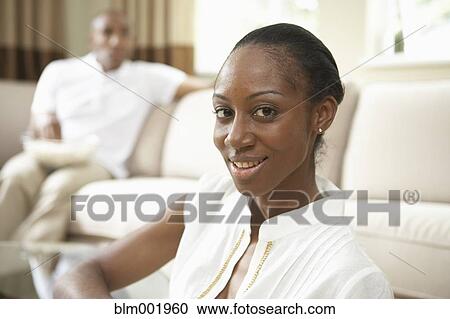 African woman smiling with African man in background View Large Photo Image Stock Image - African woman smiling with African man in background. Fotosearch