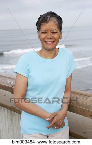 Picture - African woman standing on pier. Fotosearch
