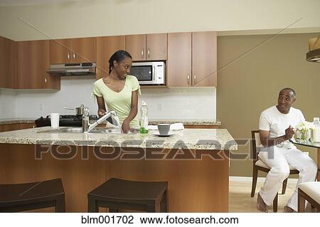 African woman washing dishes and smiling at husband View Large Photo Image Stock Image - African woman washing dishes and smiling at husband. Fotosearch