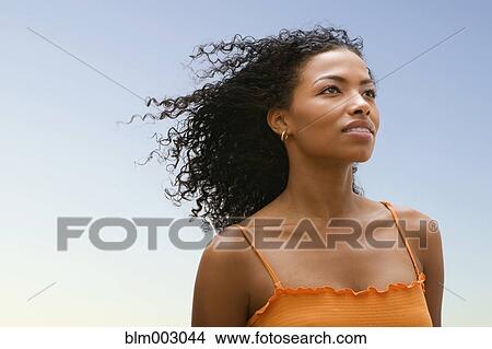 Picture - African woman's hair blowing in wind. Fotosearch