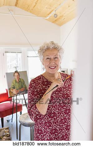 Stock Image - Artist painting in studio. Fotosearch