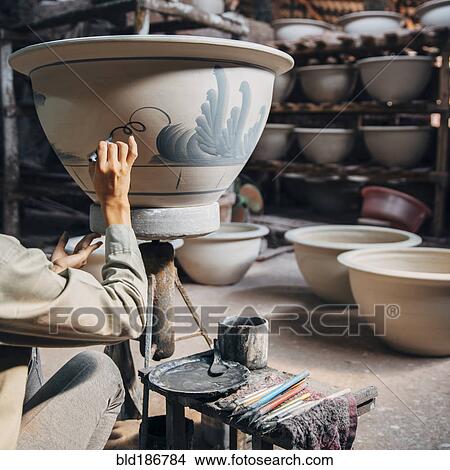 Picture - Artist painting pots in studio. Fotosearch
