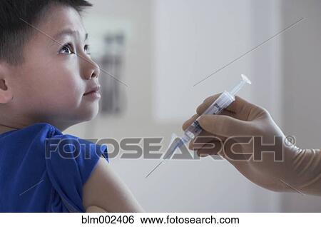 Stock Photograph - Asian boy getting shot at hospital. Fotosearch