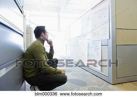 Asian businessman crouching and reviewing notes View Large Photo Image Stock Photograph - Asian businessman crouching and reviewing notes. Fotosearch