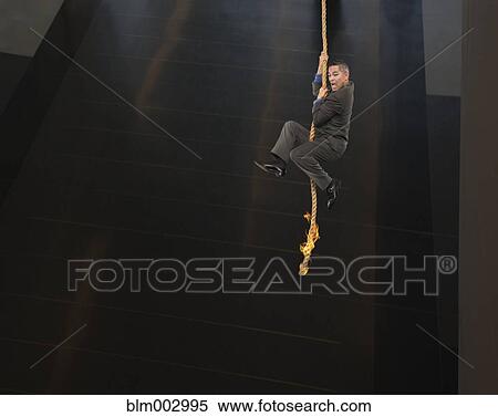 Asian businessman dangling from end of rope View Large Photo Image Stock Photography - Asian businessman dangling from end of rope. Fotosearch