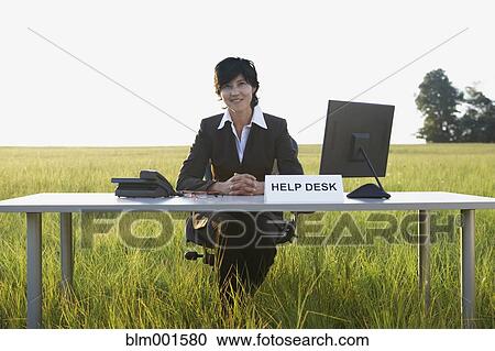 Stock Image - Asian businesswoman at Help Desk in field. Fotosearch