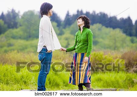 Stock Photo - Asian couple smiling at each other. Fotosearch