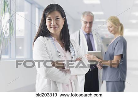 Stock Photo - Asian doctor smiling in hospital. Fotosearch