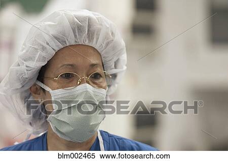 Stock Photography - Asian female doctor wearing surgical mask. Fotosearch