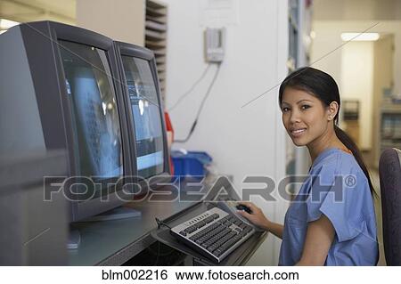Stock Photograph - Asian female medical professional in front of computer. Fotosearch