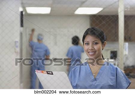 Picture - Asian female medical professional holding chart. Fotosearch