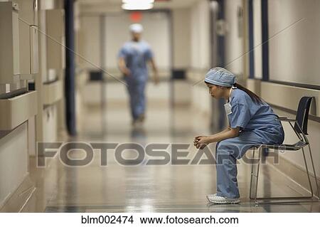 Picture - Asian female medical professional sitting in chair. Fotosearch