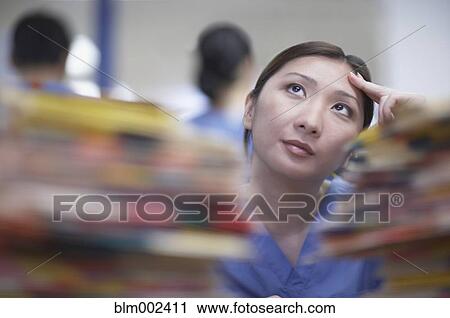 Stock Image - Asian female medical professional thinking. Fotosearch