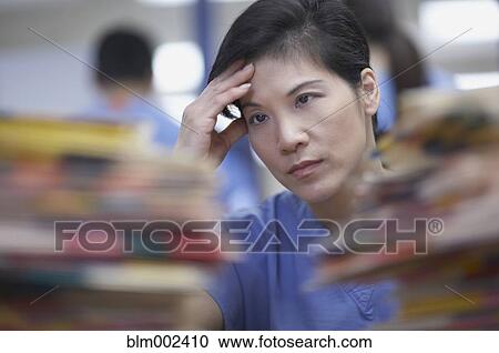 Asian female medical professional with hand on head View Large Photo Image Stock Image - Asian female medical professional with hand on head. Fotosearch