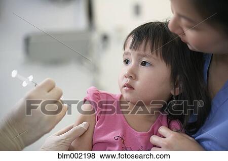 Stock Photo - Asian girl getting shot at hospital. Fotosearch