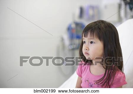 Asian girl sitting on hospital bed View Large Photo Image Stock Photo - Asian girl sitting on hospital bed. Fotosearch