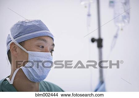 Asian male doctor wearing surgical mask View Large Photo Image Picture - Asian male doctor wearing surgical mask. Fotosearch