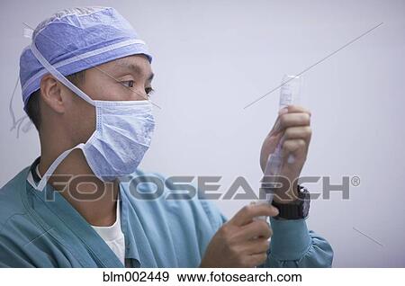 Asian male medical professional filling syringe View Large Photo Image Stock Photo - Asian male medical professional filling syringe. Fotosearch