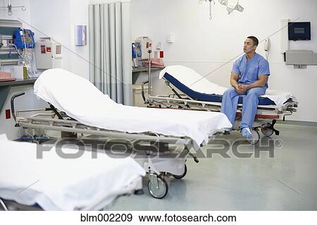 Stock Photo - Asian male medical professional in hospital bed. Fotosearch