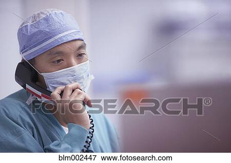 Asian male medical professional talking on telephone View Large Photo Image Stock Photo - Asian male medical professional talking on telephone. Fotosearch