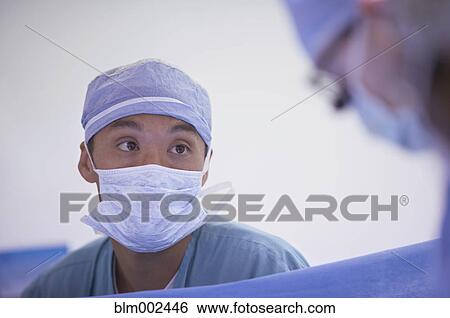 Stock Photograph - Asian male medical professional wearing surgical mask. Fotosearch