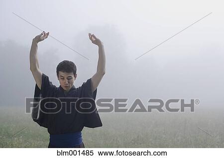 Stock Photography - Asian man exercising in traditional robe. Fotosearch