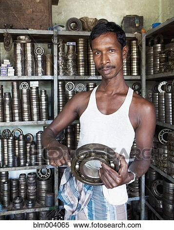 Asian man holding machine part in shop View Large Photo Image Stock Photography - Asian man holding machine part in shop. Fotosearch
