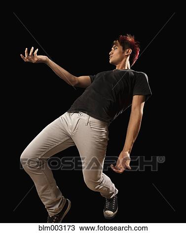 Stock Image - Asian man jumping in mid-air. Fotosearch