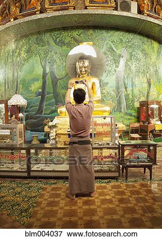 Stock Photo - Asian man photographing statue. Fotosearch