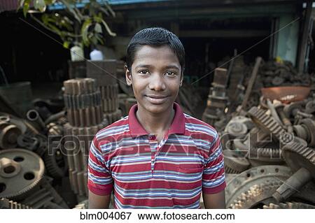 Asian man standing in front of rusted machine parts View Large Photo Image Stock Photo - Asian man standing in front of rusted machine parts. Fotosearch