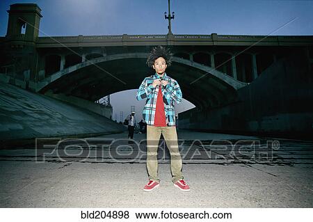 Asian man standing under overpass View Large Photo Image Stock Photo - Asian man standing under overpass. Fotosearch