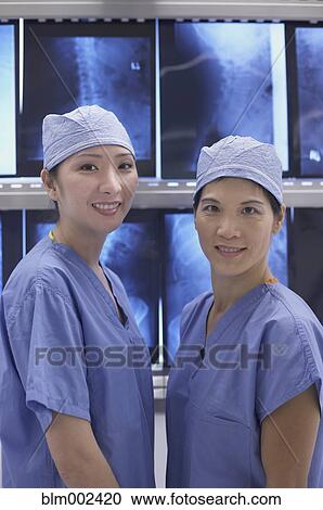 Stock Image - Asian medical professionals in front of x-rays. Fotosearch