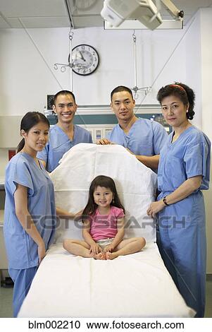 Asian medical professionals next to girl in hospital bed View Large Photo Image Stock Image - Asian medical professionals next to girl in hospital bed. Fotosearch