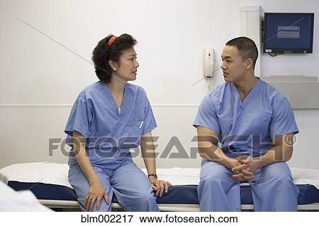 Stock Photo - Asian medical professionals talking on hospital bed. Fotosearch
