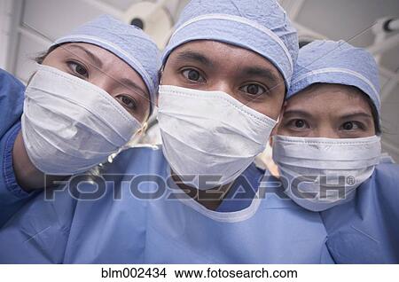 Asian medical professionals wearing surgical masks View Large Photo Image Picture - Asian medical professionals wearing surgical masks. Fotosearch