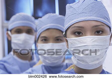 Stock Photograph - Asian medical professionals wearing surgical masks. Fotosearch