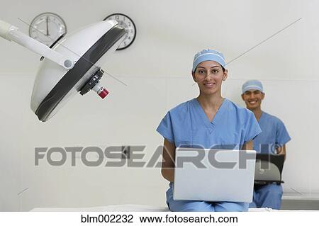 Stock Image - Asian medical professionals with laptops. Fotosearch