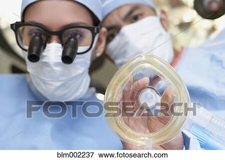 Stock Photo - Asian medical professionals with oxygen mask. Fotosearch