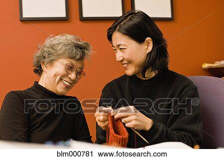 Stock Image - Asian mother and daughter knitting. Fotosearch