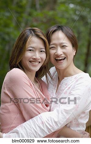 Asian sisters hugging View Large Photo Image Stock Photo - Asian sisters hugging. Fotosearch