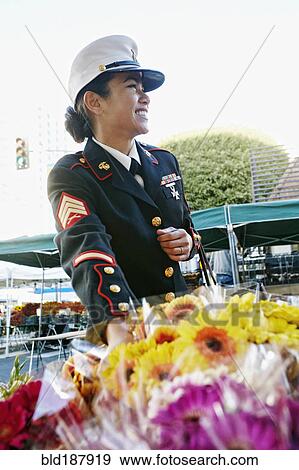 Stock Photo - Asian soldier shopping in flower market. Fotosearch