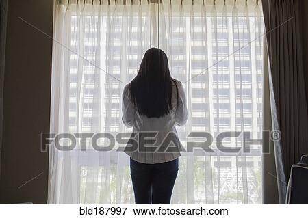 Asian teenage girl standing at hotel window View Large Photo Image Stock Photo - Asian teenage girl standing at hotel window. Fotosearch