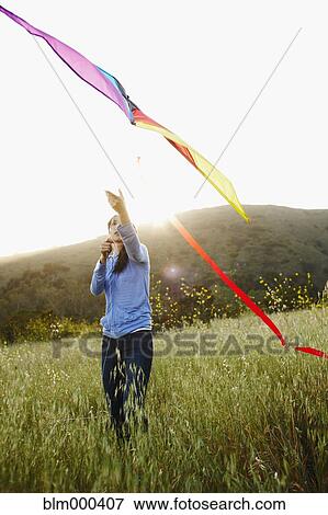 Asian woman flying kite in field View Large Photo Image Stock Photo - Asian woman flying kite in field. Fotosearch