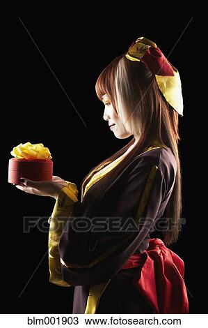 Asian woman in traditional clothing holding gift View Large Photo Image Stock Image - Asian woman in traditional clothing holding gift. Fotosearch