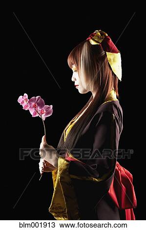 Asian woman in traditional clothing holding flower View Large Photo Image Stock Image - Asian woman in traditional clothing holding flower. Fotosearch