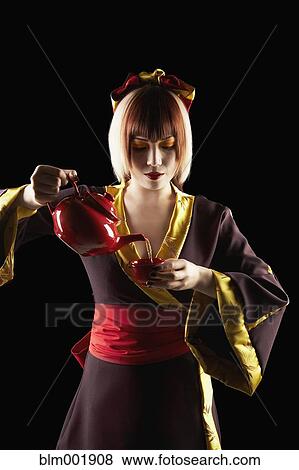 Asian woman in traditional clothing pouring tea View Large Photo Image Stock Photo - Asian woman in traditional clothing pouring tea. Fotosearch