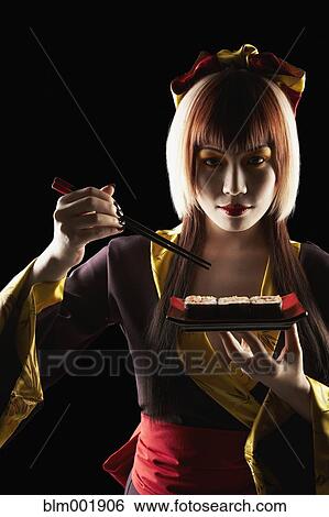 Asian woman in traditional clothing eating sushi View Large Photo Image Stock Photograph - Asian woman in traditional clothing eating sushi. Fotosearch