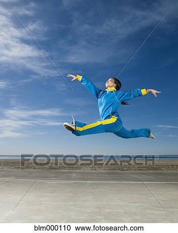 Stock Image - Asian woman jumping in air. Fotosearch