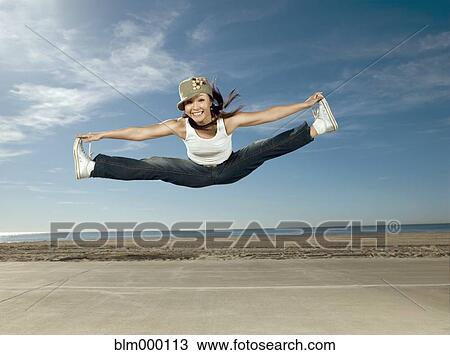 Stock Image - Asian woman jumping in air. Fotosearch