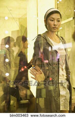 Stock Image - Asian woman looking through glass. Fotosearch